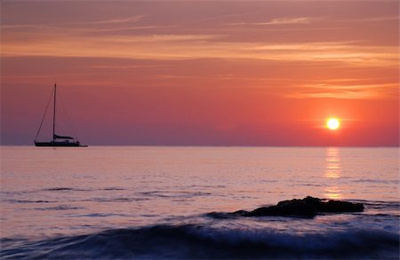 simsearch:862-03737271,k - Sailing boat silhouette and rock with surf at sunrise Stock Photo - Budget Royalty-Free & Subscription, Code: 400-04515945