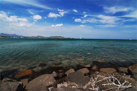 simsearch:400-04515946,k - Beautiful sea scenery on Sardinia - stones in the front, sail and blue sky with clouds Foto de stock - Super Valor sin royalties y Suscripción, Código: 400-04515950