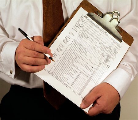 simsearch:400-05339747,k - CPA Accountant holding a clipboard with a 1040 tax form ready to fill out. Stock Photo - Budget Royalty-Free & Subscription, Code: 400-04517189