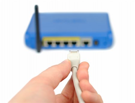 simsearch:400-05137120,k - Male hand plugging connector into wireless router isolated over white Stock Photo - Budget Royalty-Free & Subscription, Code: 400-04517994