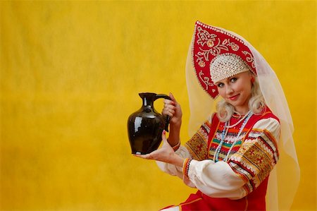 simsearch:400-05051542,k - Russian woman in a folk russian dress holds a jug on yellow background Stock Photo - Budget Royalty-Free & Subscription, Code: 400-04518177