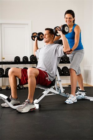 posição - Woman assisting man lifting weights at gym. Foto de stock - Royalty-Free Super Valor e Assinatura, Número: 400-04510239