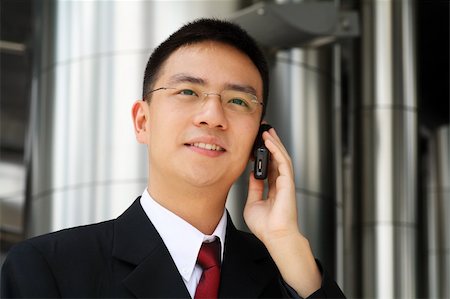 simsearch:400-04130666,k - Young asian executive talking on a handphone dressed in suit. Foto de stock - Royalty-Free Super Valor e Assinatura, Número: 400-04511424