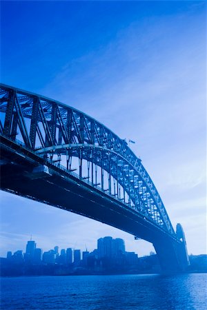 simsearch:400-04006297,k - Low angle view of Sydney Harbour Bridge in Australia with view of harbour and downtown skyline. Foto de stock - Royalty-Free Super Valor e Assinatura, Número: 400-04512405