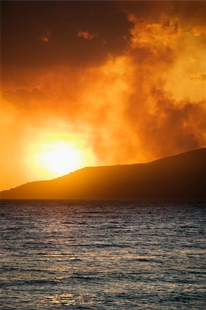 simsearch:400-04006467,k - Sun setting over island with ocean on Maui, Hawaii. Photographie de stock - Aubaine LD & Abonnement, Code: 400-04512513