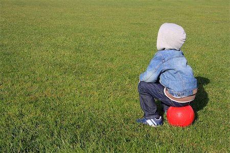 A little boy with a red ball on a green field with copy-space for text Stock Photo - Budget Royalty-Free & Subscription, Code: 400-04524339