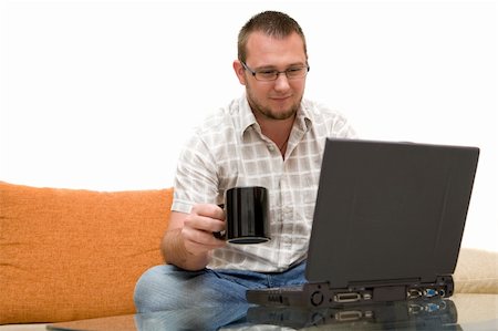 simsearch:400-04651437,k - happy man sitting on sofa with laptop Stockbilder - Microstock & Abonnement, Bildnummer: 400-04525324