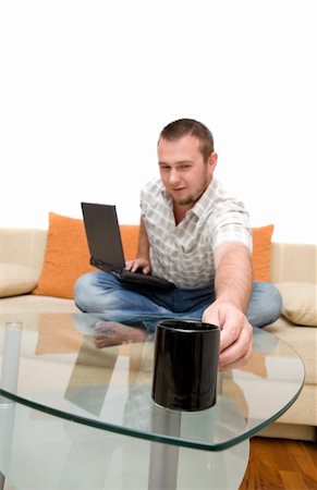 simsearch:400-04999709,k - happy man sitting on sofa with laptop Photographie de stock - Aubaine LD & Abonnement, Code: 400-04525328