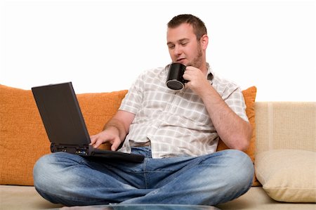 simsearch:400-04999709,k - happy man sitting on sofa with laptop Photographie de stock - Aubaine LD & Abonnement, Code: 400-04525344
