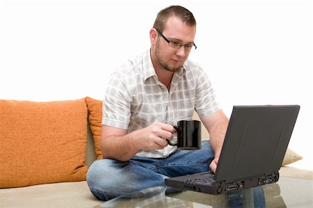 simsearch:400-04651437,k - happy man sitting on sofa with laptop Stockbilder - Microstock & Abonnement, Bildnummer: 400-04525342