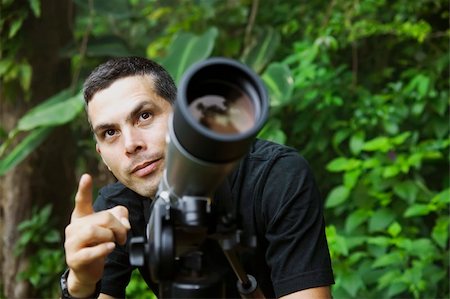 person focusing telescope - Handsome nature guide with a telescope in the rainforest Stock Photo - Budget Royalty-Free & Subscription, Code: 400-04525668