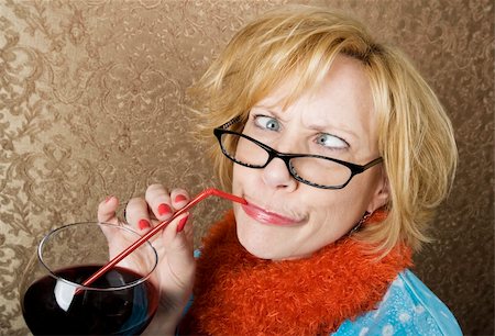 Crazy woman with crossed eyes drinking wine through a straw Stock Photo - Budget Royalty-Free & Subscription, Code: 400-04526578