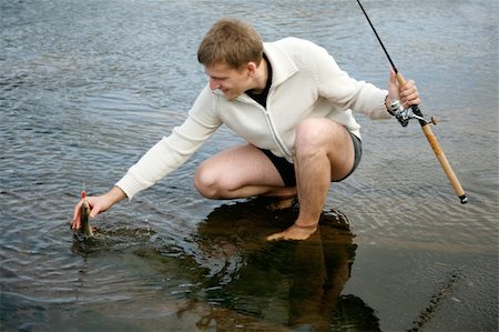 man catching fish Photographie de stock - Aubaine LD & Abonnement, Code: 400-04526618