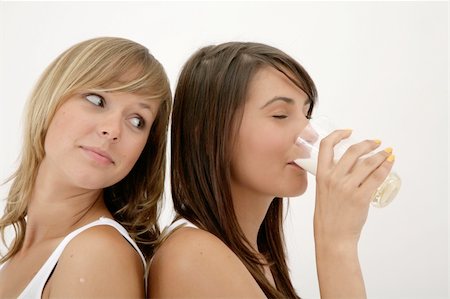 close-up of two girls over white background, one drinking milk Stock Photo - Budget Royalty-Free & Subscription, Code: 400-04526866