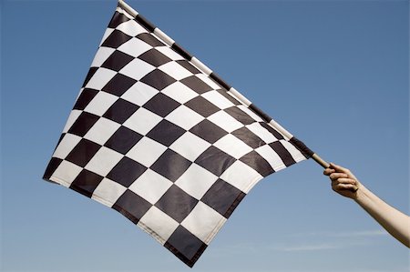 Auto racing checkered flag on a background of the  blue sky. Stockbilder - Microstock & Abonnement, Bildnummer: 400-04527099