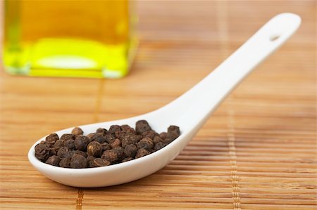 simsearch:400-04047920,k - Peppercorns in the spoon and oil bottle for prepare tasty food with soft shadow in the bamboo mat background. Shallow depth of field Stock Photo - Budget Royalty-Free & Subscription, Code: 400-04527299