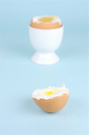 Hard boiled eggs and egg cups isolated against a blue background Stock Photo - Budget Royalty-Free & Subscription, Code: 400-04528035