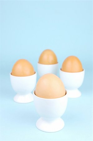 Hard boiled eggs and egg cups isolated against a blue background Stock Photo - Budget Royalty-Free & Subscription, Code: 400-04528030