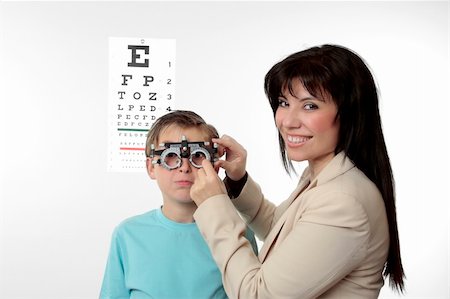 patient and doctor consultation diversity - An optometrist putting trial frames on a child.  She is looking around and smiling. Stock Photo - Budget Royalty-Free & Subscription, Code: 400-04528513