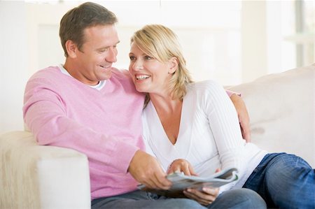 Couple relaxing with a magazine and smiling Stock Photo - Budget Royalty-Free & Subscription, Code: 400-04528751