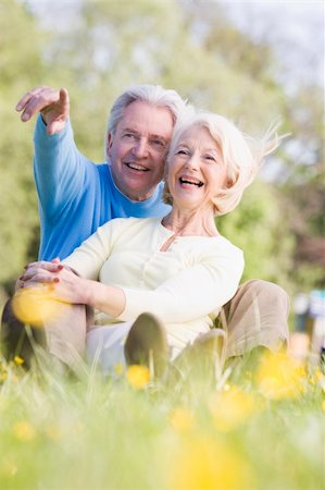 Couple relaxing outdoors pointing and smiling Stock Photo - Budget Royalty-Free & Subscription, Code: 400-04528795