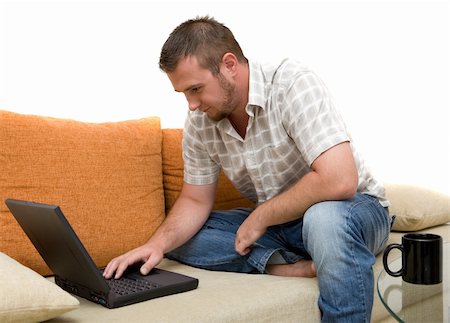 simsearch:400-04651437,k - happy man sitting on sofa with laptop Stockbilder - Microstock & Abonnement, Bildnummer: 400-04529699