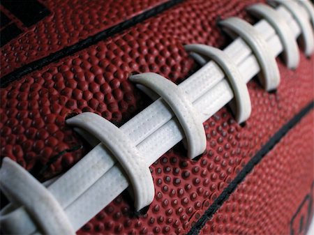 pigskin - Close-up shot showing the white laces and dimpled surface of an American football. Photographie de stock - Aubaine LD & Abonnement, Code: 400-04520132