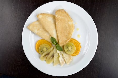 Pancakes with fruit on a white plate. Stockbilder - Microstock & Abonnement, Bildnummer: 400-04520415