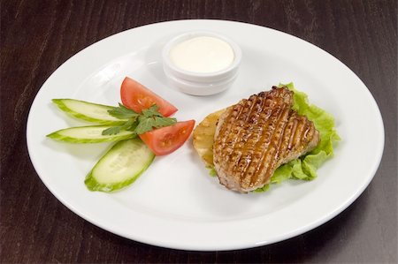 Piece of fried meat with vegetables on a white plate. Stockbilder - Microstock & Abonnement, Bildnummer: 400-04520450