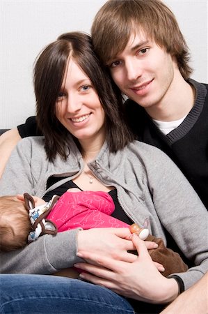 young parents on a sofa with their baby girl Stock Photo - Budget Royalty-Free & Subscription, Code: 400-04520637