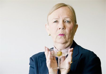 simsearch:400-08040653,k - Dramatic senior woman in a man's suit holding a Martini. Stock Photo - Budget Royalty-Free & Subscription, Code: 400-04520675