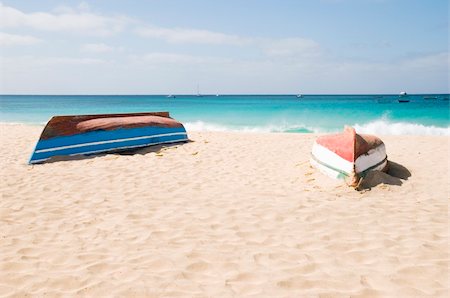 Two upturned fishing boats lay on a beautiful sandy beach in the Cape verde islands. Foto de stock - Super Valor sin royalties y Suscripción, Código: 400-04523157