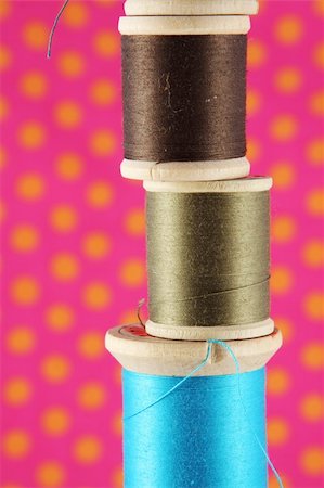Spools of thread stacked in front of a bright polka dot background Stock Photo - Budget Royalty-Free & Subscription, Code: 400-04523967