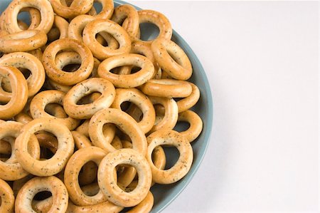 Heap of bread ring in a blue plate on a white background. Stockbilder - Microstock & Abonnement, Bildnummer: 400-04534285