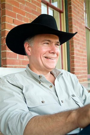 A man sitting on a porch wearing a cowboy hat with a big happy smile on his face. Photographie de stock - Aubaine LD & Abonnement, Code: 400-04535263