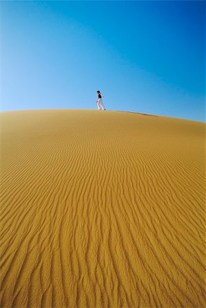simsearch:400-04034980,k - Woman walking across desert sand dune Foto de stock - Royalty-Free Super Valor e Assinatura, Número: 400-04535461