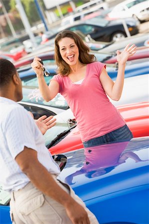 Woman picking up keys to new car from lot Stock Photo - Budget Royalty-Free & Subscription, Code: 400-04536046