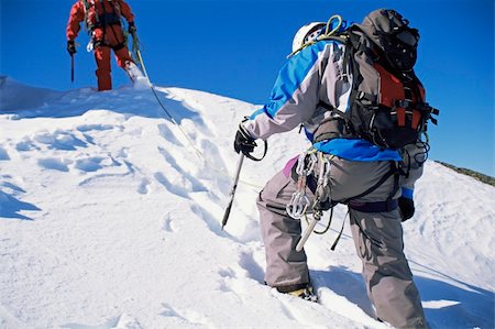 simsearch:400-08506088,k - Young men mountain climbing on snowy peak Fotografie stock - Microstock e Abbonamento, Codice: 400-04536310