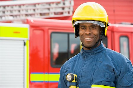 simsearch:400-04036456,k - Portrait of a firefighter standing in front of a fire engine Foto de stock - Royalty-Free Super Valor e Assinatura, Número: 400-04536459