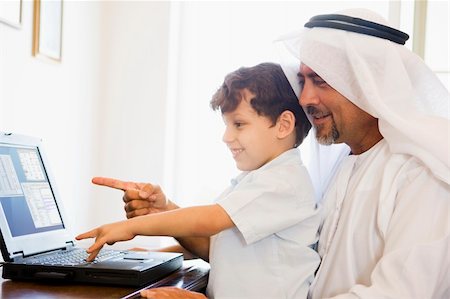 simsearch:400-04037075,k - A Middle Eastern man and his son sitting in front of a computer Stock Photo - Budget Royalty-Free & Subscription, Code: 400-04536712