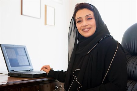 A Middle Eastern woman sitting in front of a computer at home Stock Photo - Budget Royalty-Free & Subscription, Code: 400-04536713