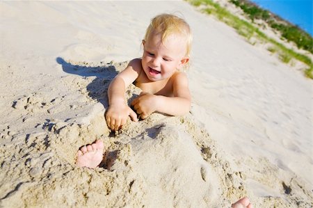 Young girl buried in the sand smiling at camera Stock Photo - Budget Royalty-Free & Subscription, Code: 400-04537521