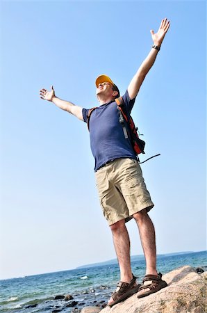 simsearch:400-04044871,k - Middle aged hiker standing on top of a mountain raising his arms Photographie de stock - Aubaine LD & Abonnement, Code: 400-04538149