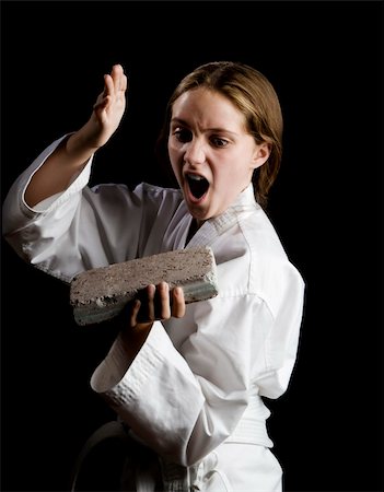 Young girl karate chopping a brick on black background Fotografie stock - Microstock e Abbonamento, Codice: 400-04538516