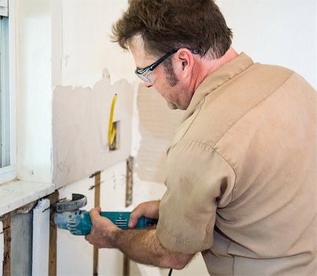 simsearch:400-04494971,k - Electrician using a grinder to cut through insulation in a wall.   Authentic and accurate content depiction in accordance with industry code and safety standards. Stock Photo - Budget Royalty-Free & Subscription, Code: 400-04539165