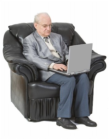 Image of a senior man siting in an armchair and using a laptop,isolated against a white background. Stock Photo - Budget Royalty-Free & Subscription, Code: 400-04539718