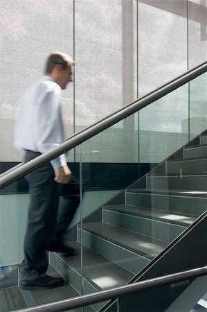 Motion blurred image of businessman climbing a stairway in an office building Stock Photo - Budget Royalty-Free & Subscription, Code: 400-04531503
