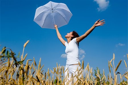 Happy young girl with umbrella in the field. Smiling face Stock Photo - Budget Royalty-Free & Subscription, Code: 400-04532385