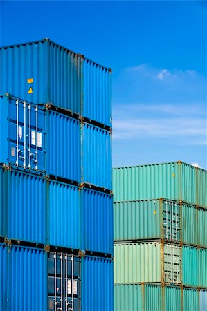 sascha (artist) - shipping cargo containers stacked under a blue sky at freight terminal Fotografie stock - Microstock e Abbonamento, Codice: 400-04532824