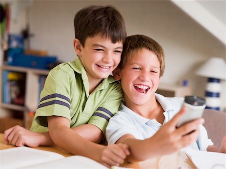 Two Young Boys Distracted From Their Homework, Playing With A Ce Stock Photo - Budget Royalty-Free & Subscription, Code: 400-04544167